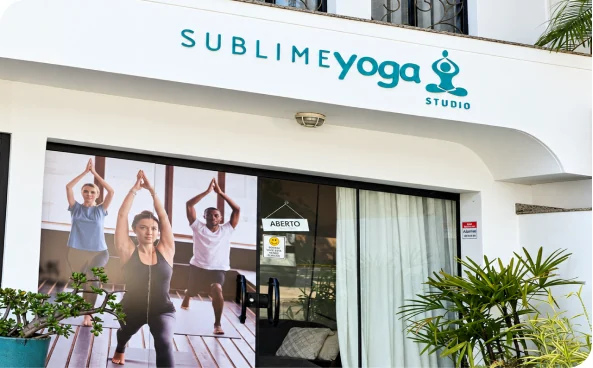 Fachada do Studio Sublime Yoga, com entrada envidraçada e plantas.