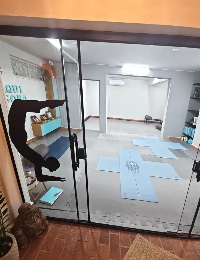 Sala de práticas com mats de Yoga organizados no chão.