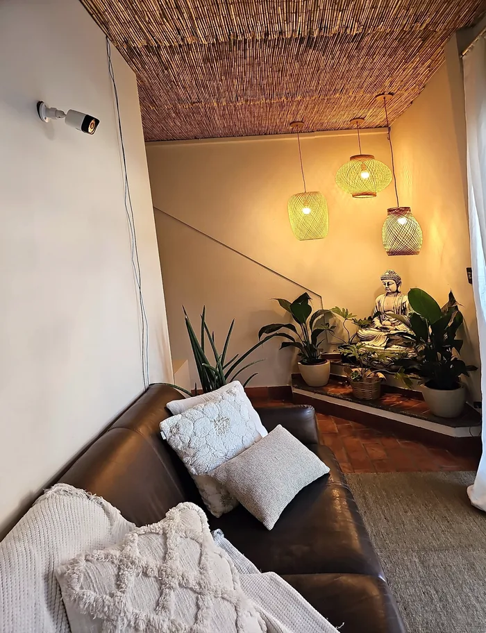 Espaço de acolhimento com poltrona, plantas e iluminação suave.